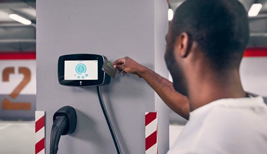 Mann aktiviert Wallbox Ladelösung von Stromquelle mit einer Ladekarte